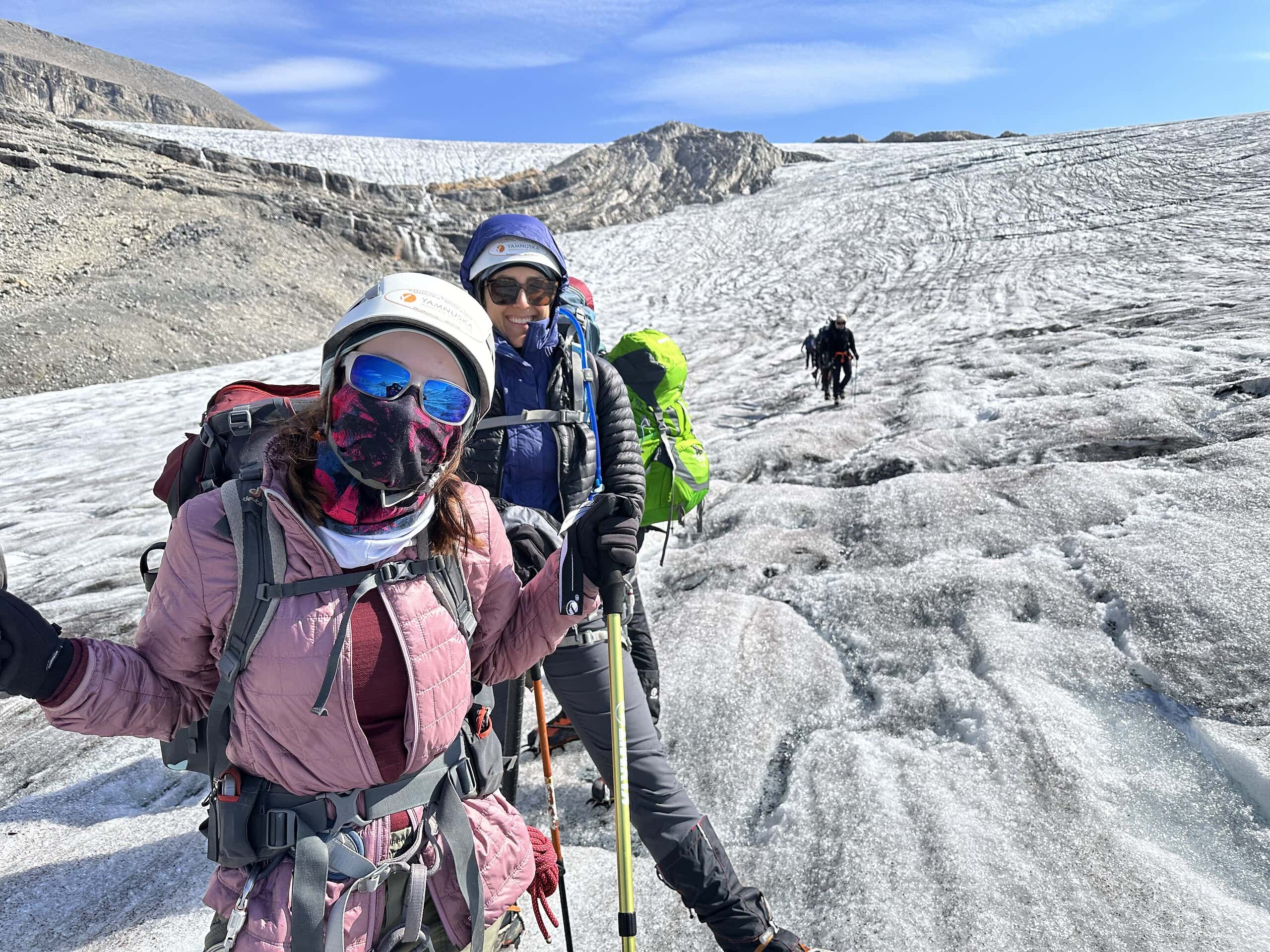 Two Explorer Chick women hiking in windy conditions wearing buffs and hiking gear