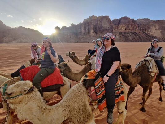 women riding camels on an adventure trip