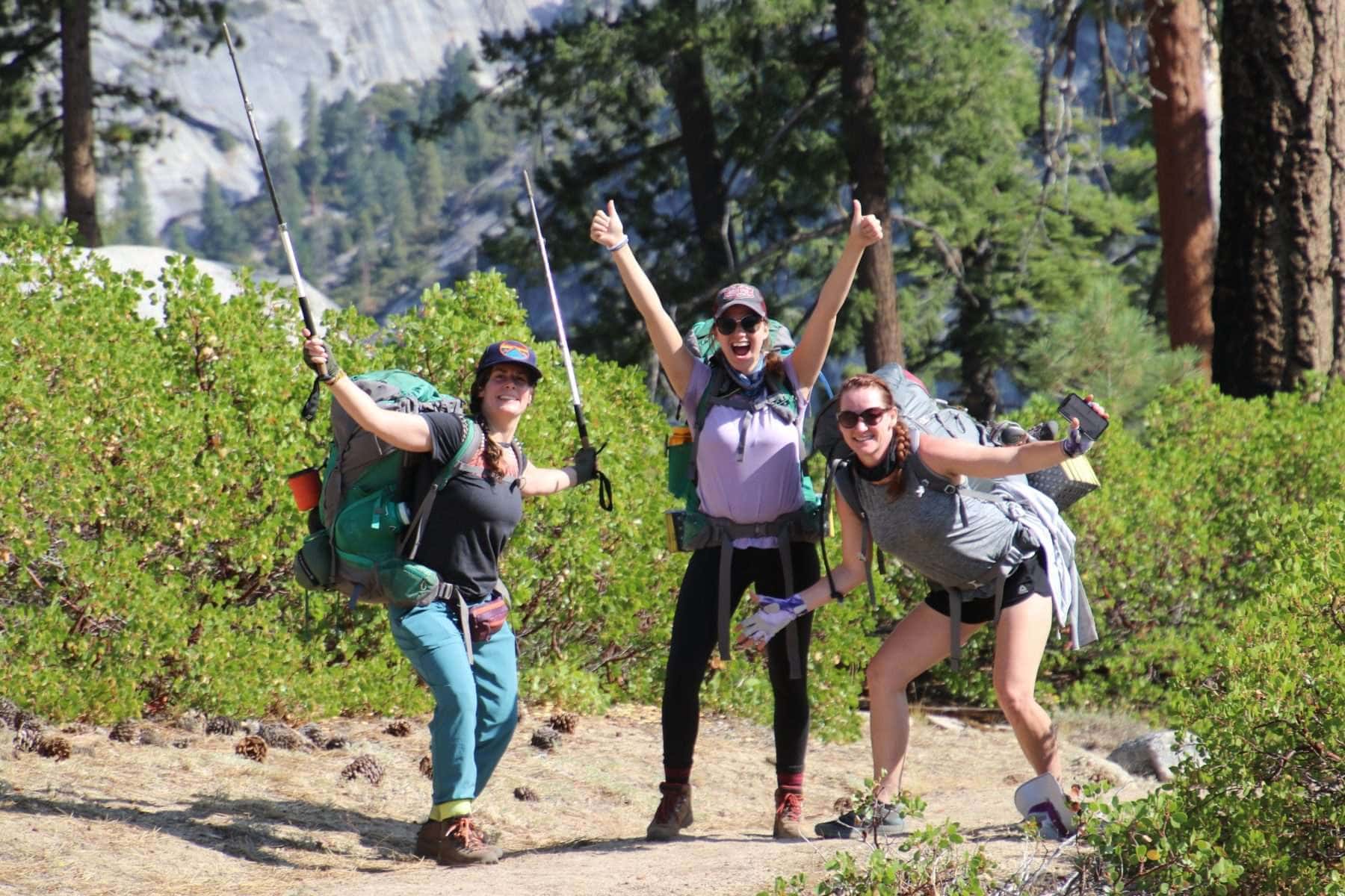 Women posing with backpacks and trekking poles in Yosemite National Park