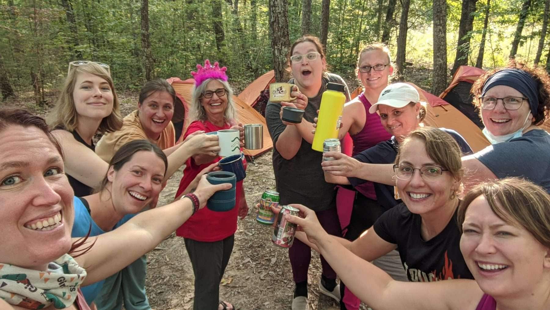 women playing drinking games while camping outdoors