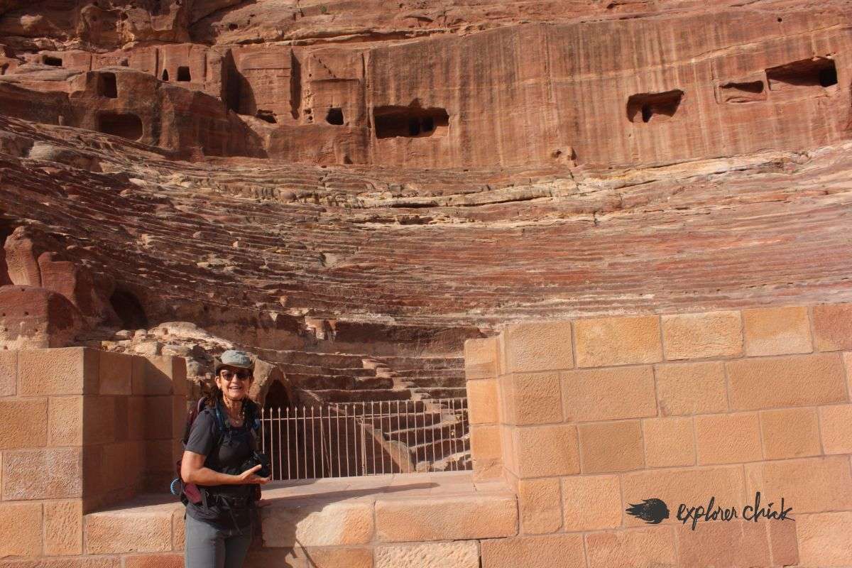 woman stands in front of the theater of Petra