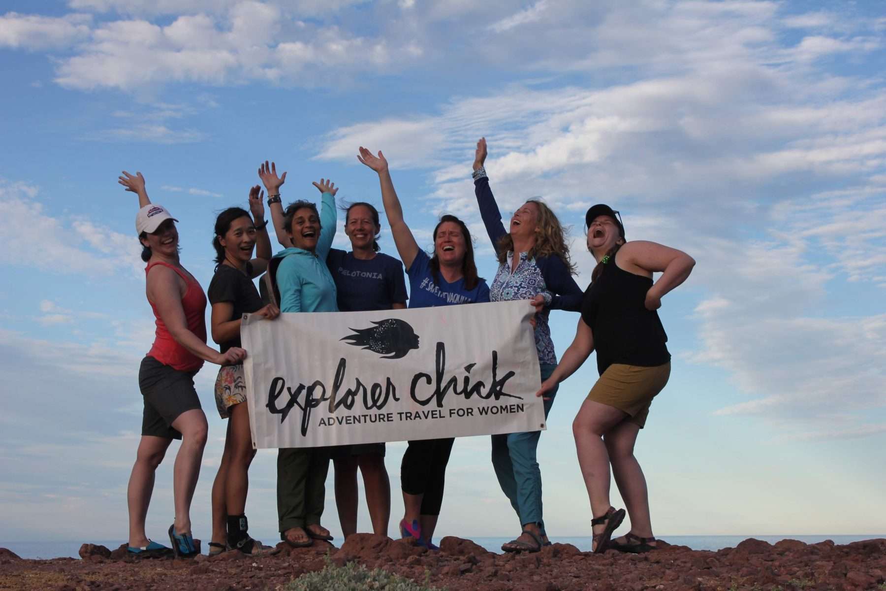 Women holding a banner from the guided tour travel company Explorer Chick.