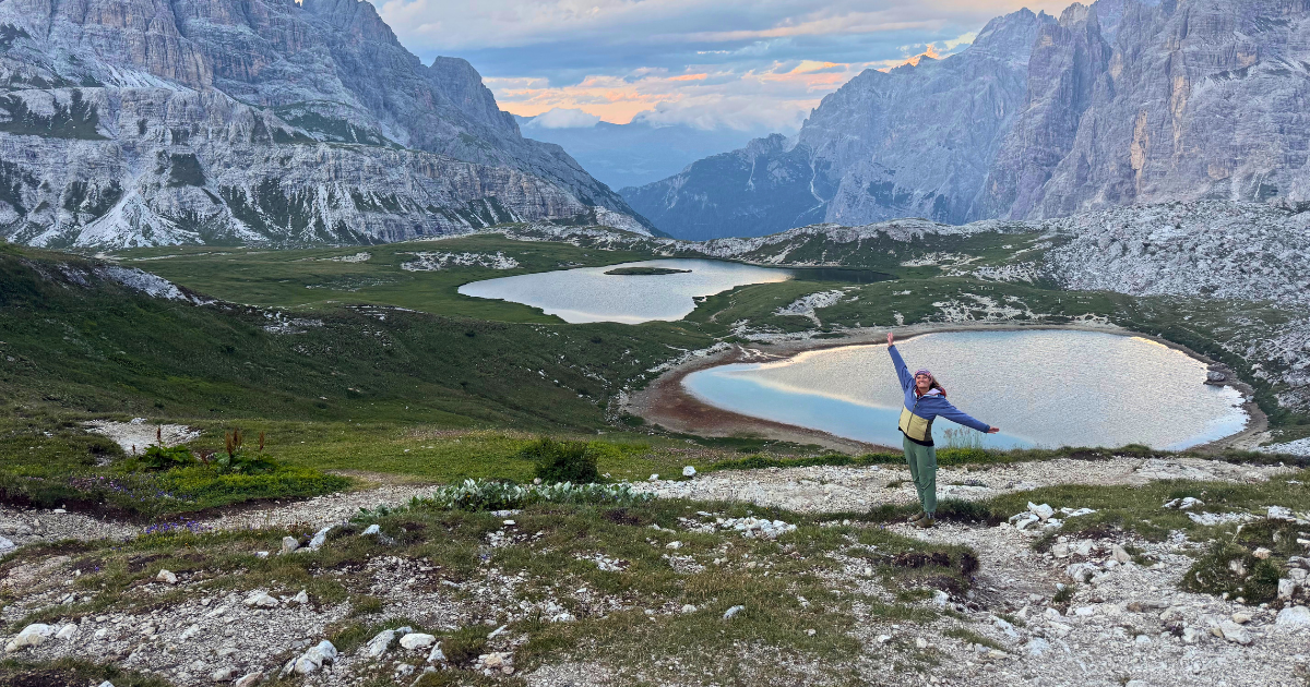 Woman overlooking alpine lakes on a women’s hiking adventure in the Italian Dolomites