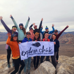 the explorer chick team on a hike in red rock canyon in las vegas with our team banner