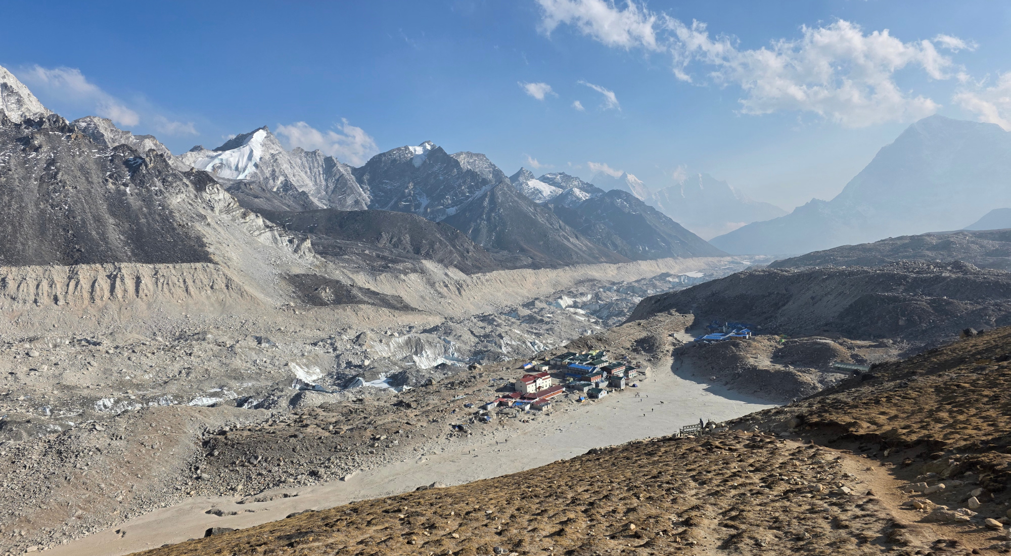 A cluster of colorful lodges and teahouses fills the valley below snowcapped Himalayan peaks, a common overnight stop for trekkers to Everest Base Camp.