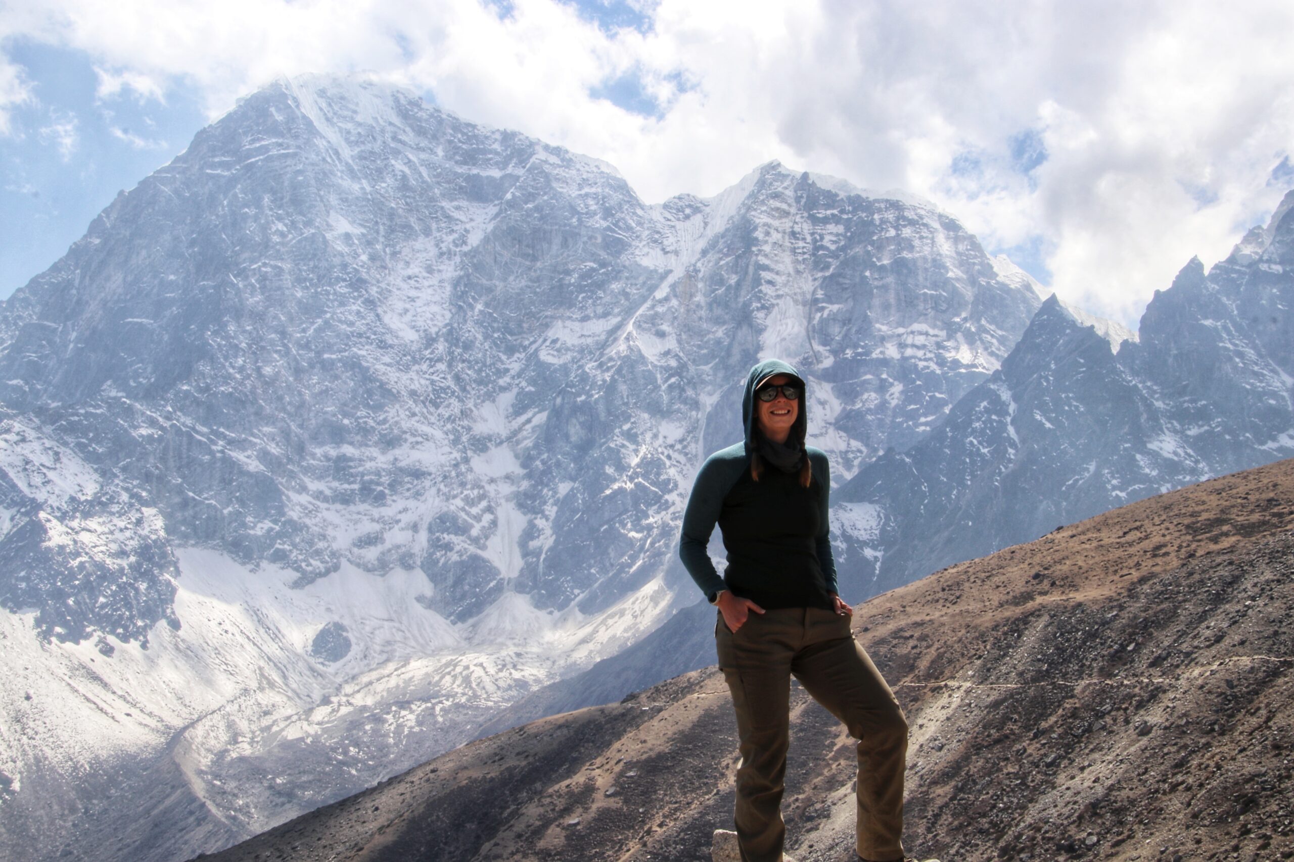 woman trekking to everest basecamp in nepal with mountains in the background.