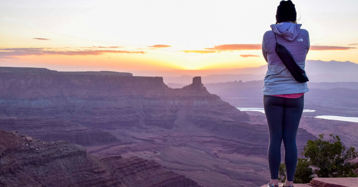 Explorer Chick women’s hiking weekend trip in Moab Utah overlooking Dead Horse Point at sunset
