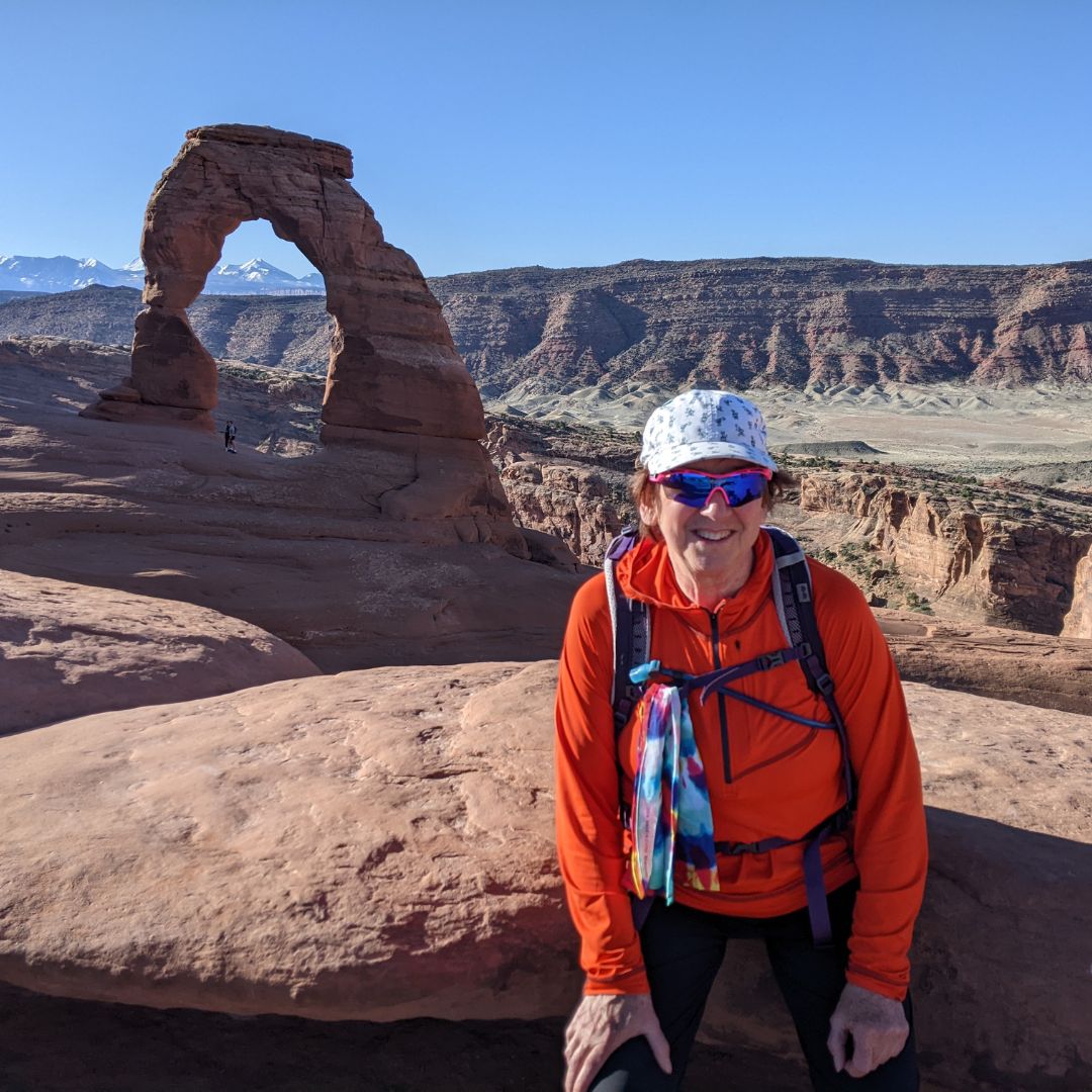 Woman hiking near Delicate Arch in Arches National Park in Moab, Utah during an Explorer Chick adventure